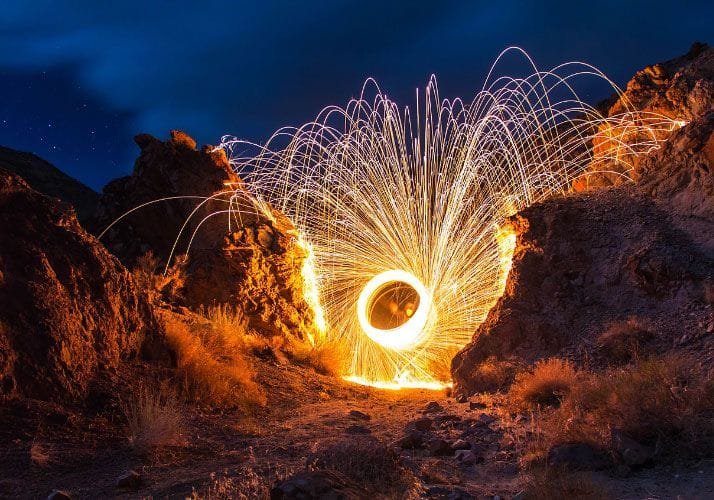 People Firing Sparklers Between Rocks